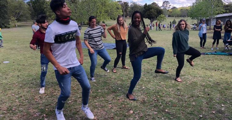 Young people teach each other cultural dances at a You Belong Welcome Party.