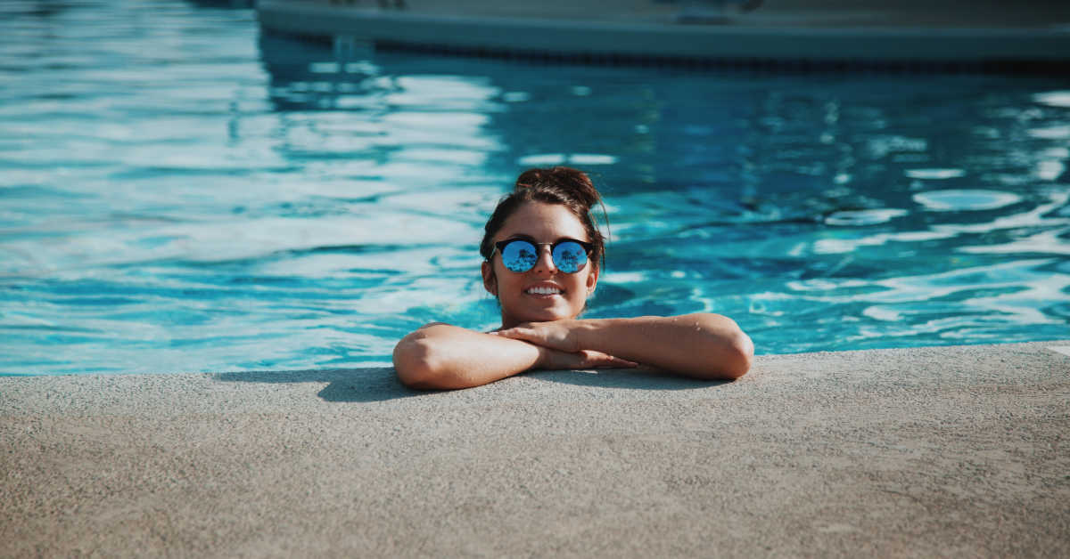 Young adult leaning on the side of pool